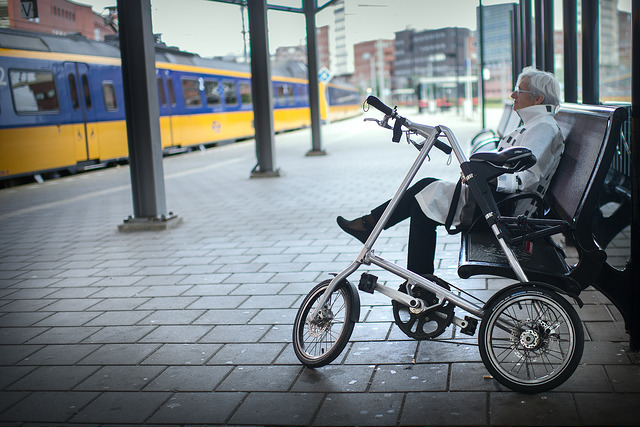 Vrouw wacht met vouwfiets op de trein