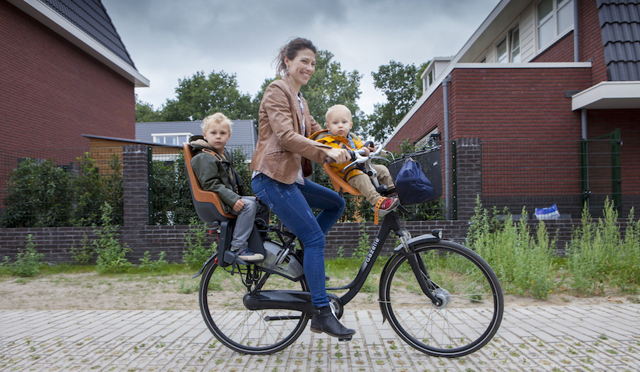 Kirsten, Joas (3) en Seth (1) op de fiets met kinderzitjes
