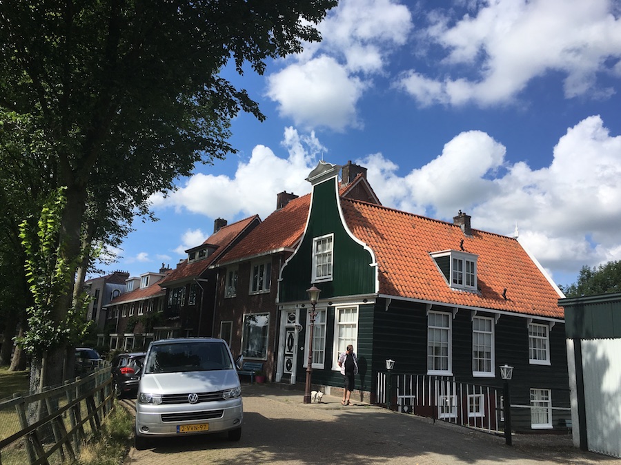 Foto van de Nieuwendammerdijk met een groene houten klokgevel.