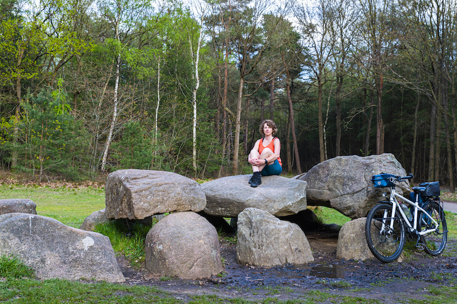 Jessica op Hunebed met haar fiets tegen een steen