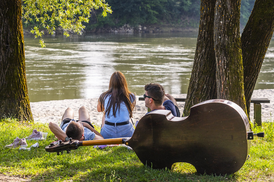Picknickende jongeren aan de oever van een rivier