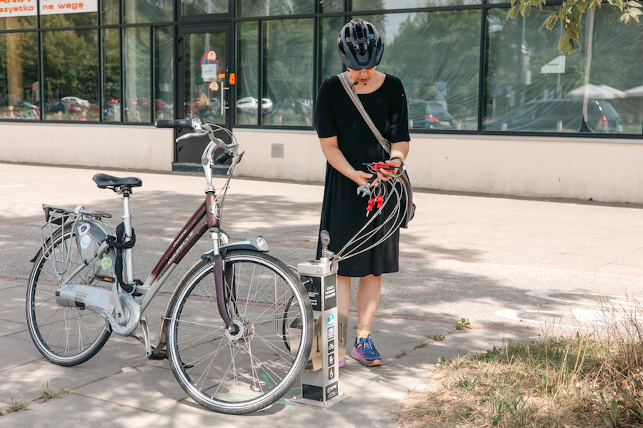 Een vrouw zet haar fiets op slot