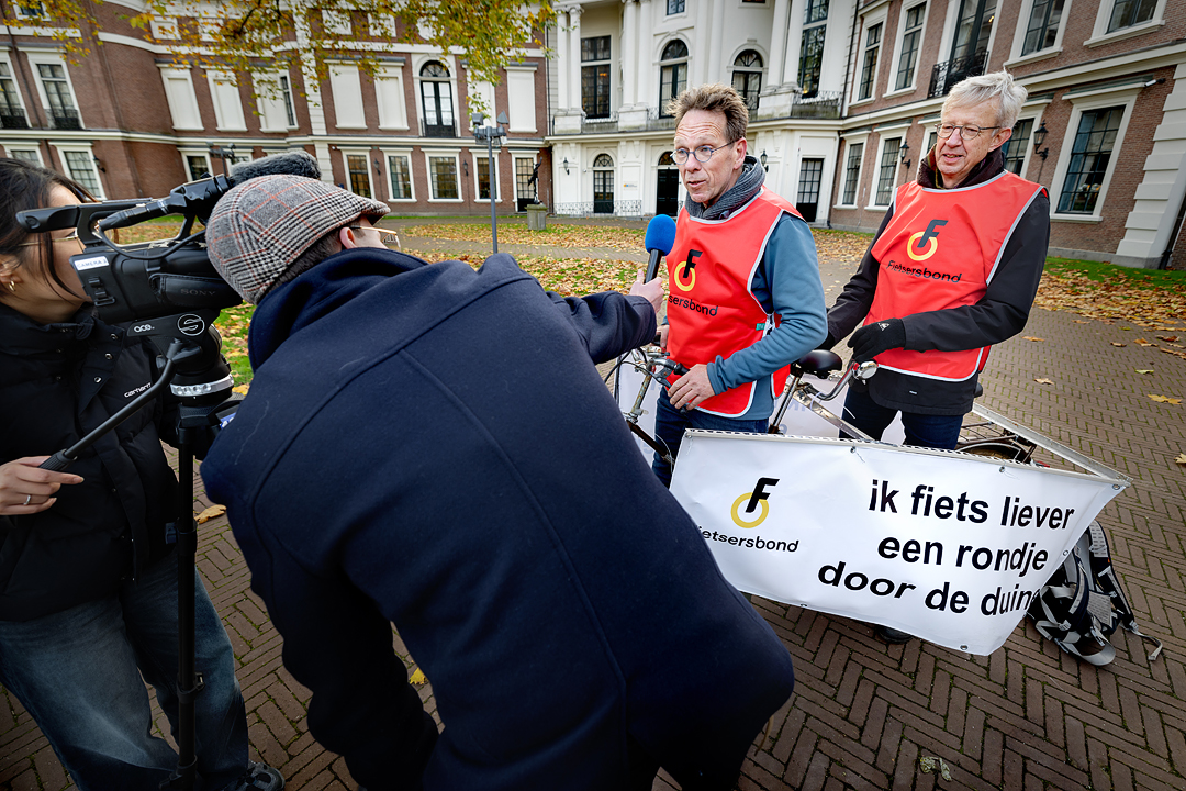 Vrijwilligers van de Fietsersbond worden geïnterviewd voor de camera. Ze dragen een rood hesje met het logo van de Fietsersbond erop.