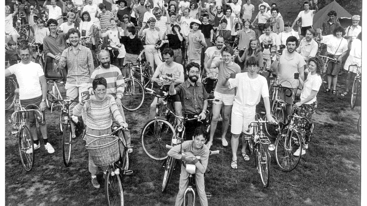 Een grote groep fietsers proost op een geslaagd evenement.