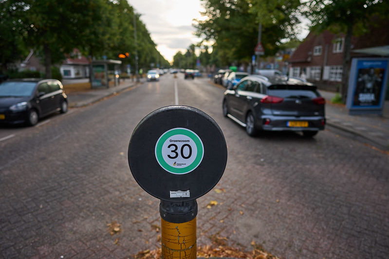 De Groenezoom in Rotterdam. In het midden is de achterkant van een verkeersbord te zien met een actiesticker 30 km/u erop.