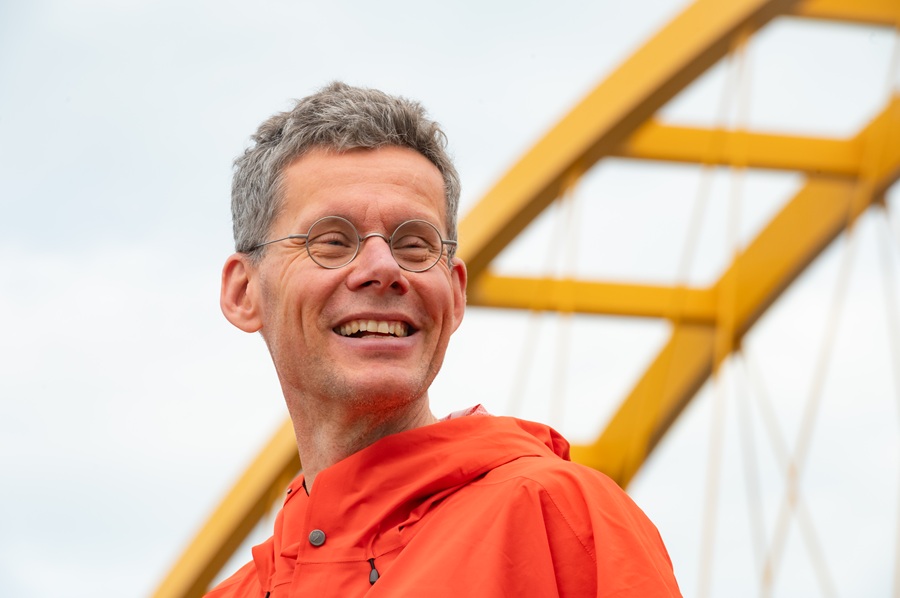 Lachende man met knaloranje jas.