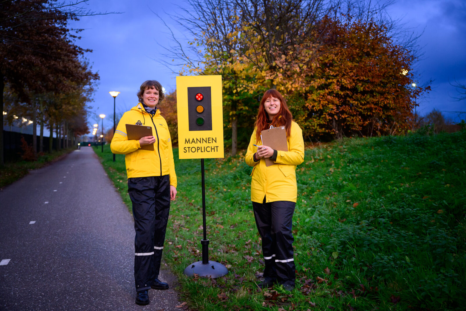 Twee vrouwen staan aan weerszijden van het Mannenstoplicht.
