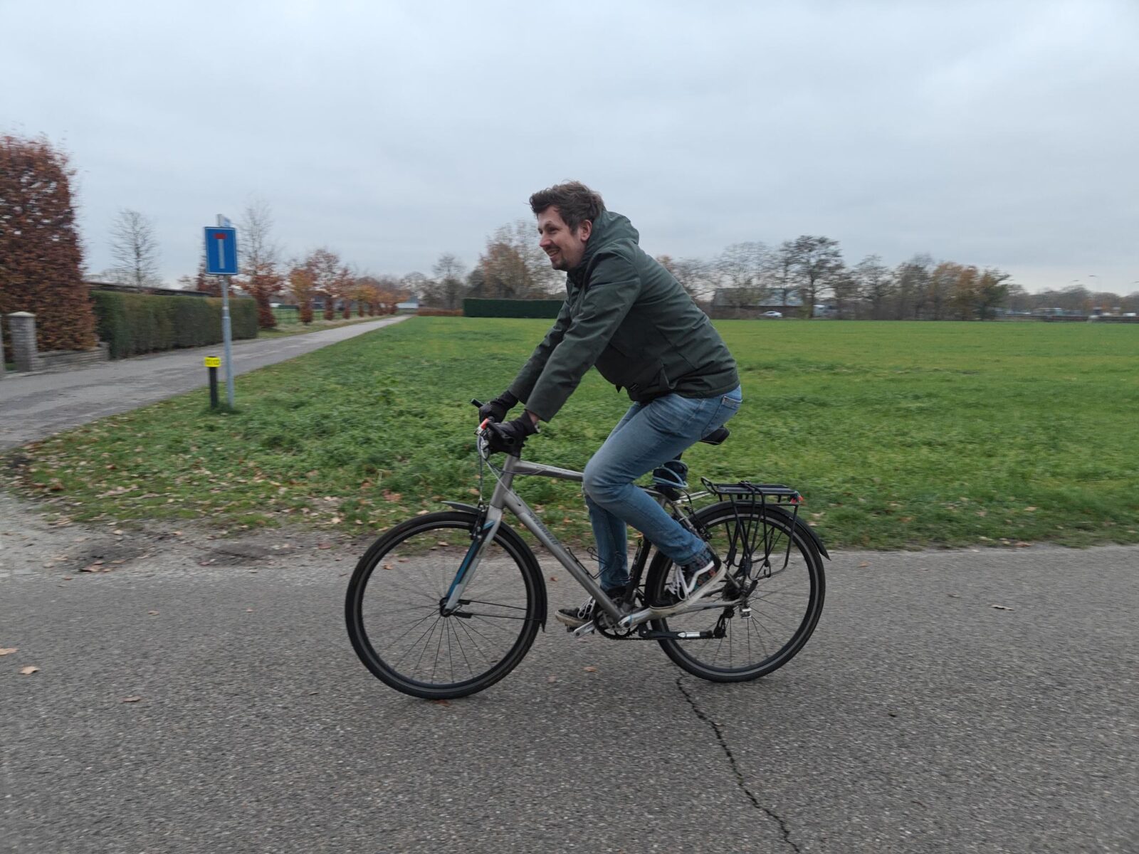 Man rijdt in winterkleding met handschoenen aan op sportieve fiets.
