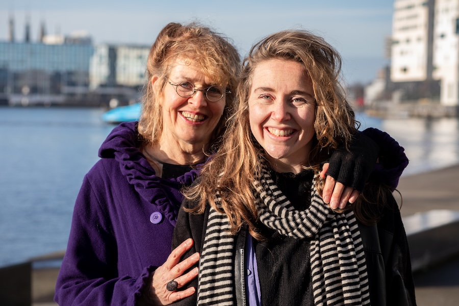 Twee vrouwen in winterjassen bij het IJ in Amsterdam.